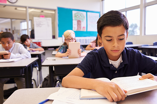 Boy reading book in class