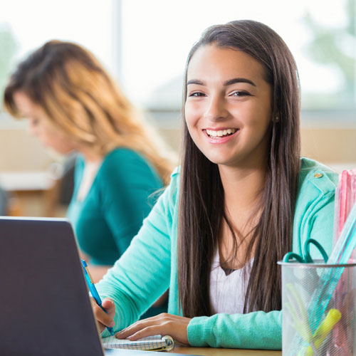 Student at laptop smiling