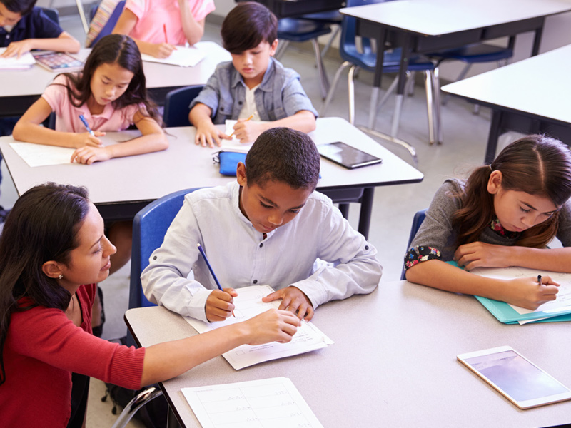Teacher helping student with writing