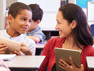 Teacher and Student Smiling Using Tablets
