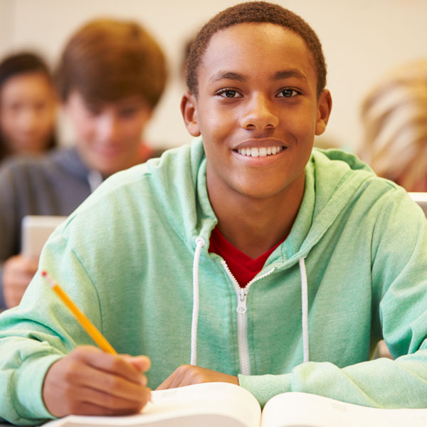 Student smiling with math book on desk